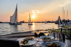 Zeilboten en sfeervol diner aan het water tijdens zonsondergang in Friesland